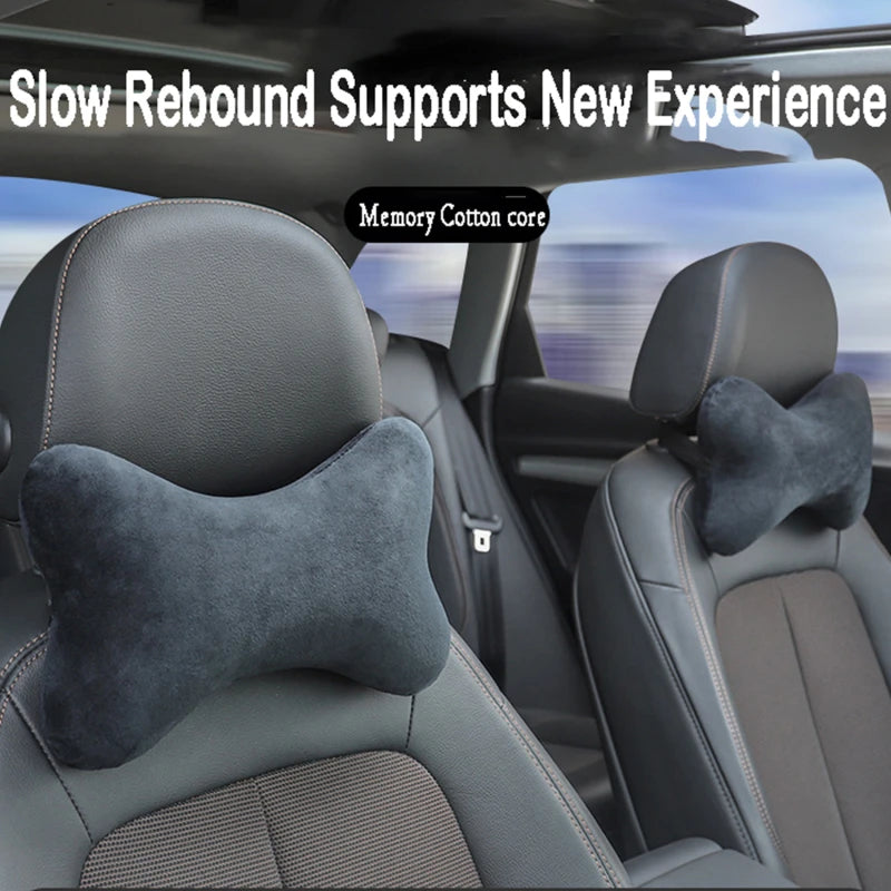 A close-up view of a dark gray car seat with a memory cotton core neck pillow placed on the headrest.