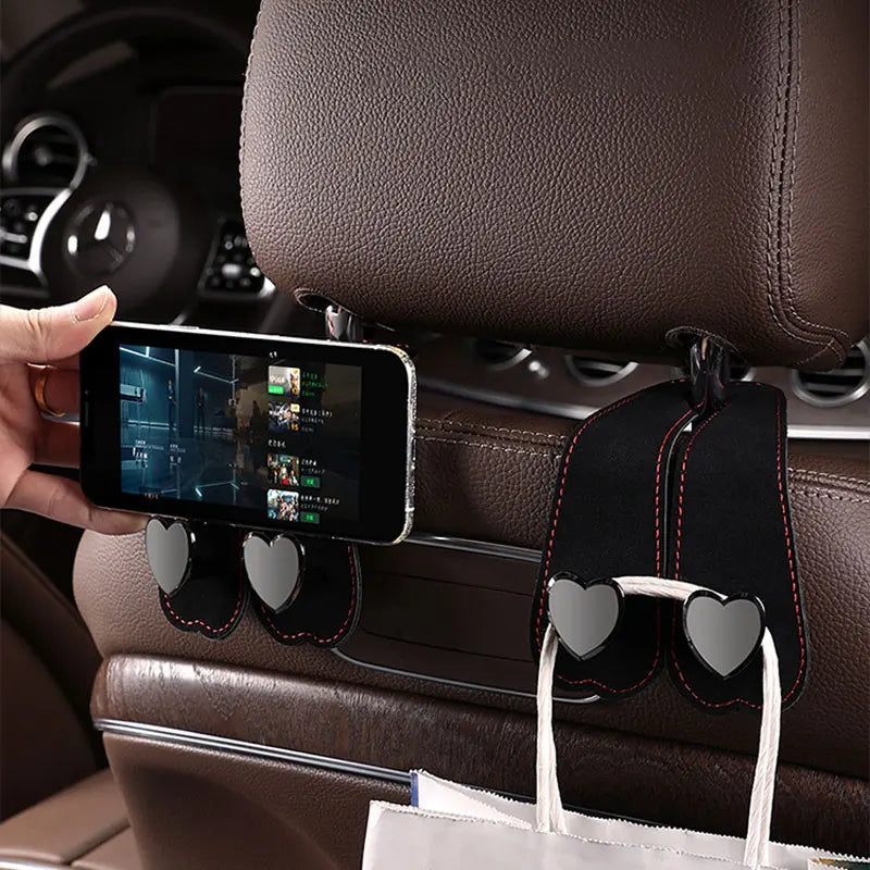 Schwarze Doppel-Haken-Sitzlehnenhalterung auf braunem Leder im Autointerieur.