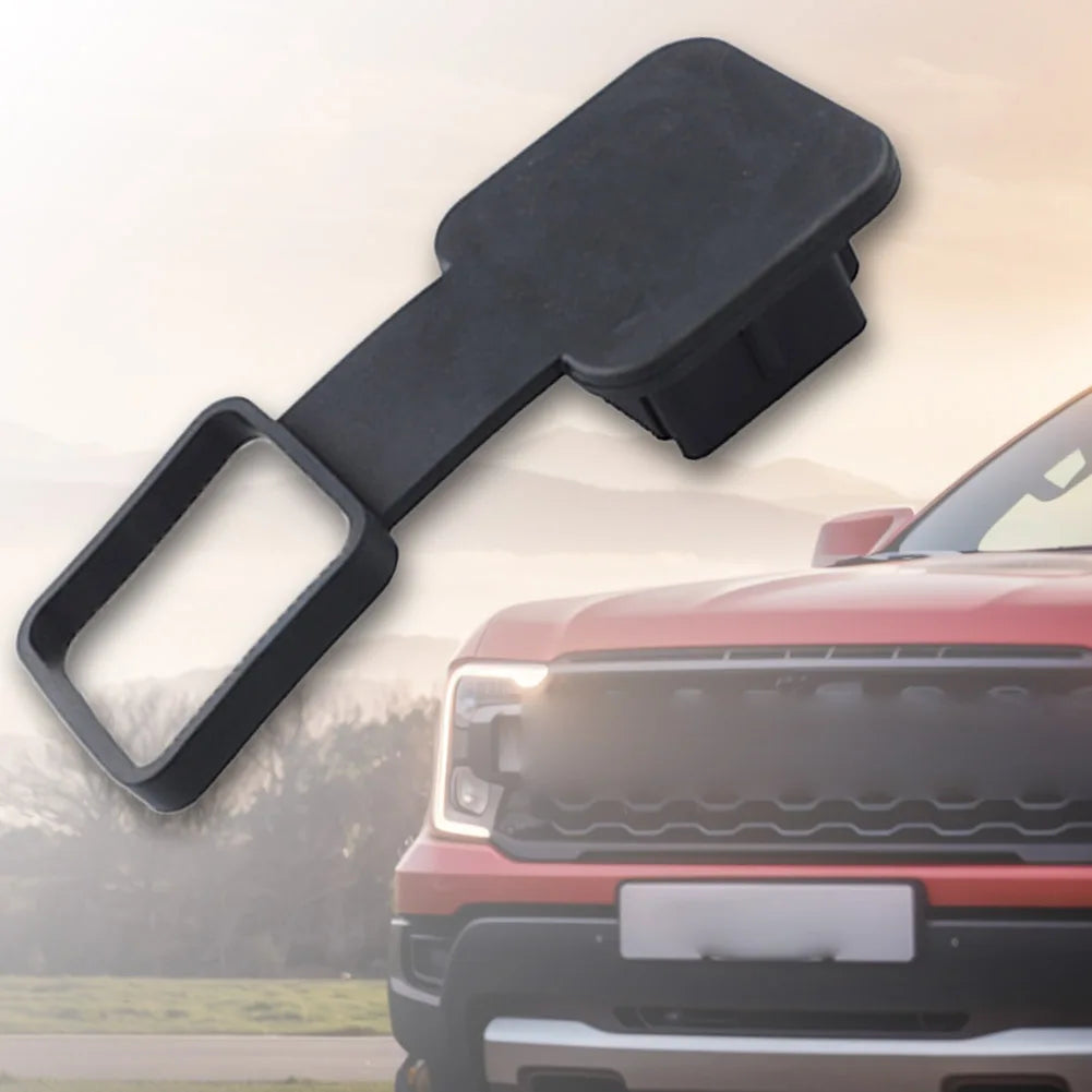 Ein schwarzer Anhängerkupplungsabdeckpass wird neben einem roten Pickup-Truck gezeigt.