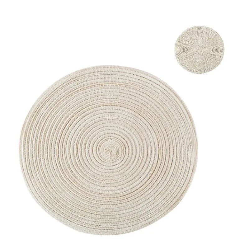 Un ensemble de dessous-de-verre et de sets à couverts tressés ronds de couleur beige naturel.