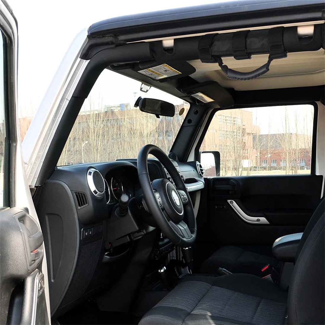 Interior view of a Jeep showing durable Oxford roll bar grab handles installed on the door frame.
