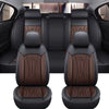 A pair of black car seat covers with brown stitching and leather accents shown in a vehicle interior.