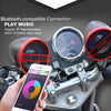 A hand holds a smartphone near a motorcycle Bluetooth speaker system with an FM radio and USB, showing a music interface.