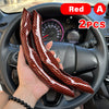 A pair of red and black patterned universal car steering wheel booster covers shown in a hand on a car steering wheel.