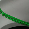 A close-up view of a green magnetic strip for car sheet metal dry grinding, curved across a white surface.