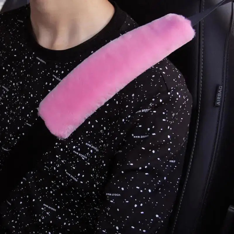 A close-up of a pink foam shoulder pad attached to a black garment.