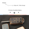 A close-up view of a brown silicone TPU car key cover protector with a key inserted, shown against a black textured backgroun
