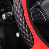 Primer plano de una cubierta de volante acolchada negra con un acento rojo en el interior de un vehículo.