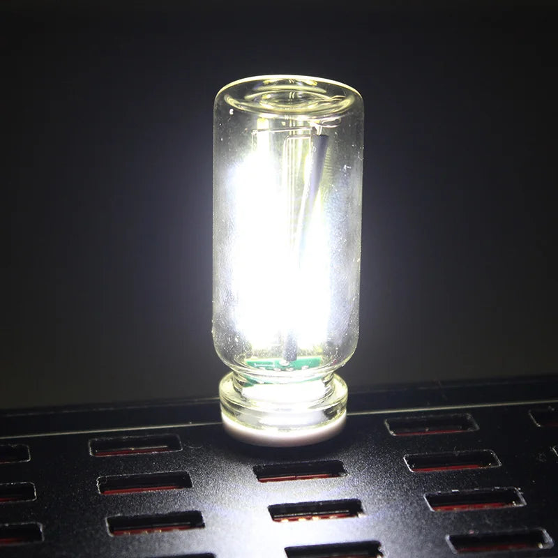 Klares Glas-Auto-Nachtlicht mit LED-Birne auf einer schwarzen Gitteroberfläche.