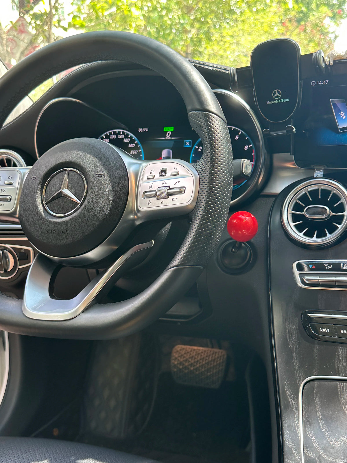 Interior view of a car dashboard showing the steering wheel and controls.
