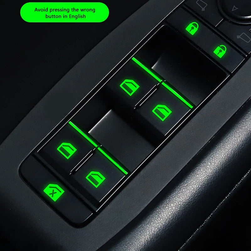 Close-up of a black car window control panel showing green luminous buttons for operation.