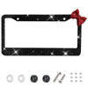 Black glitter license plate frame with a red bow accent and mounting hardware.