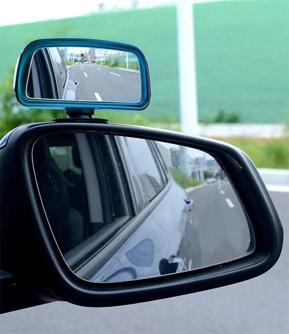 Miroir convexe noir monté sur un véhicule, offrant un large champ de vision et un reflet de la route.