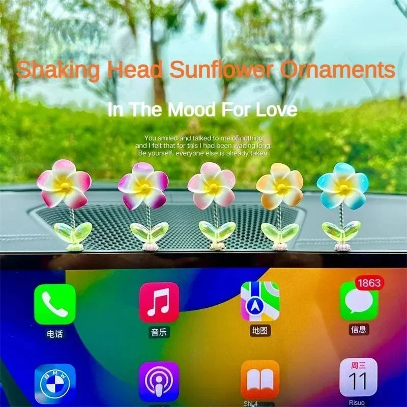 Ornements de tournesols qui secouent, roses, violets et jaunes, exposés sur une console.