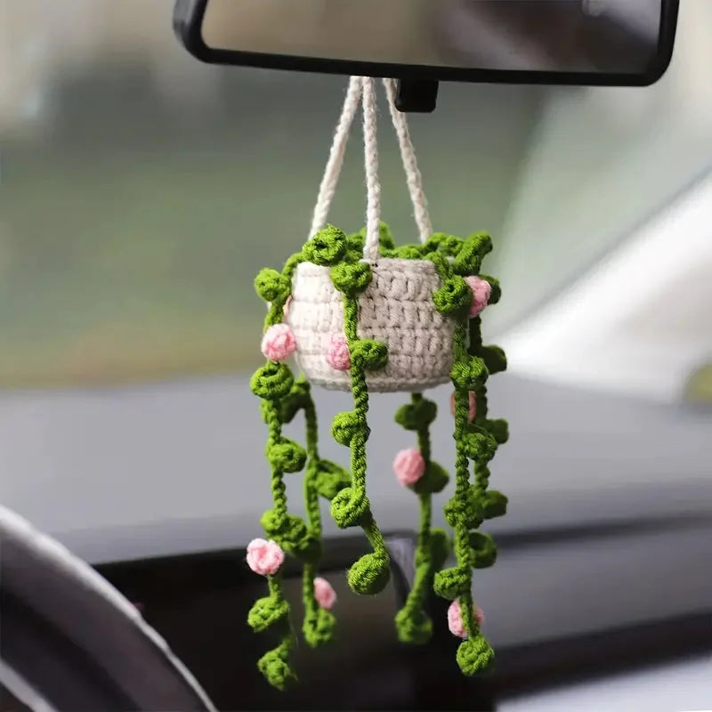 Strawberry crochet hanging car decor featuring a white woven pot with green leaves and pink flowers