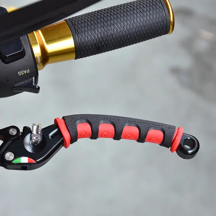 Close-up of a black and red brake lever cover for a motorcycle, showing the grip and mounting mechanism.