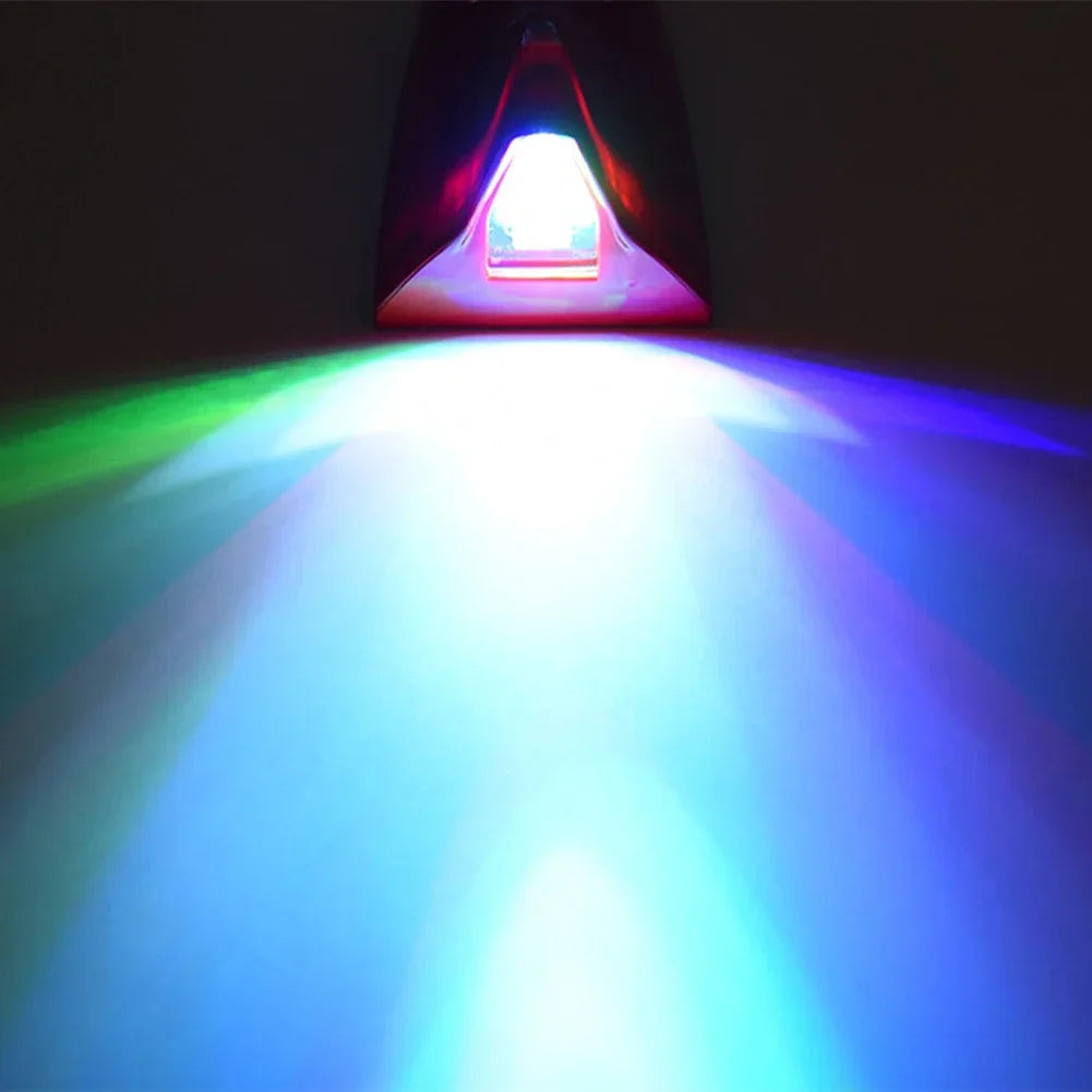 A bright white light beam shines forward from a shark fin roof light, illuminating the surrounding area with green and blue h