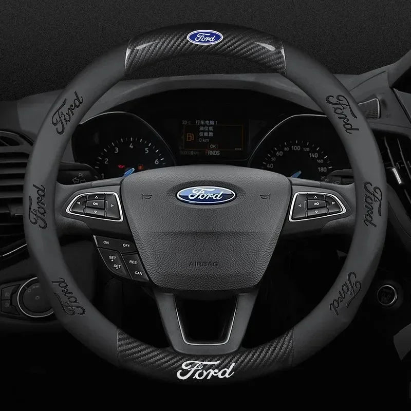 A close-up view of a black carbon fiber steering wheel cover for a Ford vehicle interior.