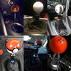 A collection of gear shift knobs and adapters showing various styles, including a white ball knob and an orange ball knob.