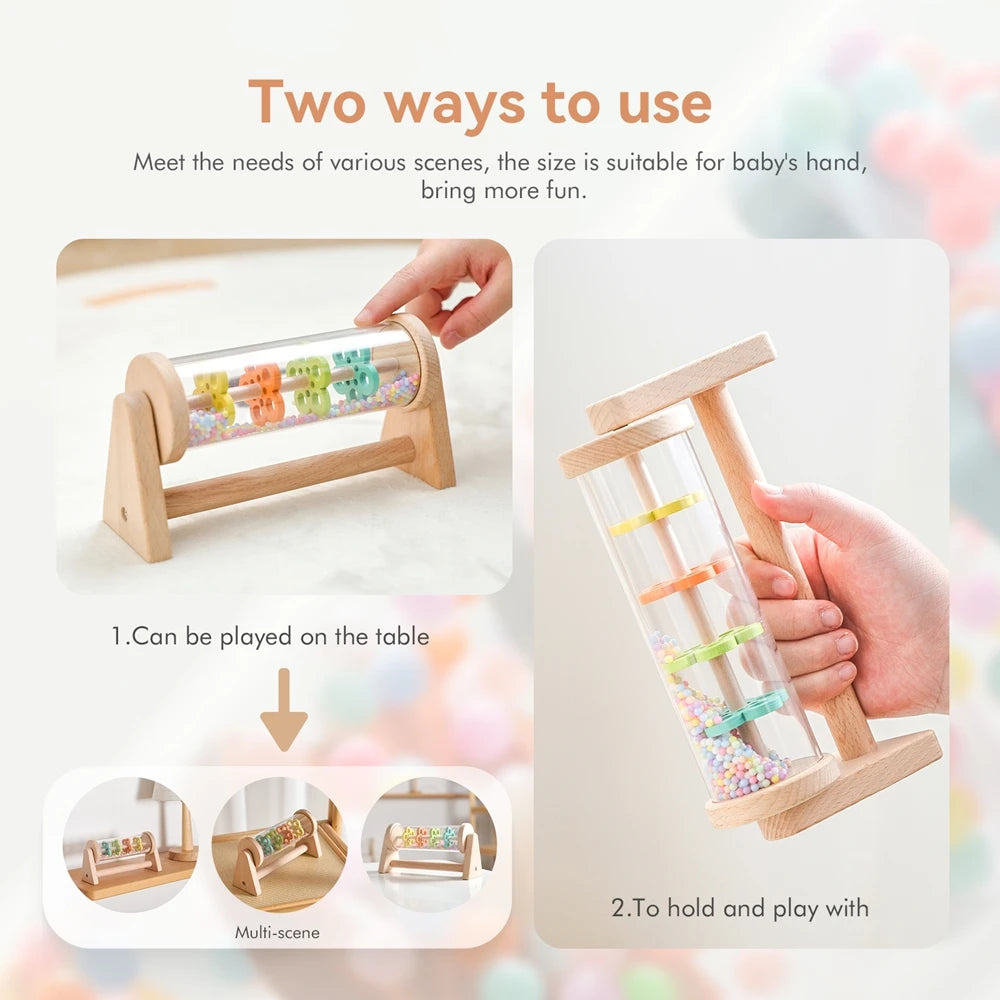 A wooden rainmaker musical toy is shown being held and played with by a baby's hand.