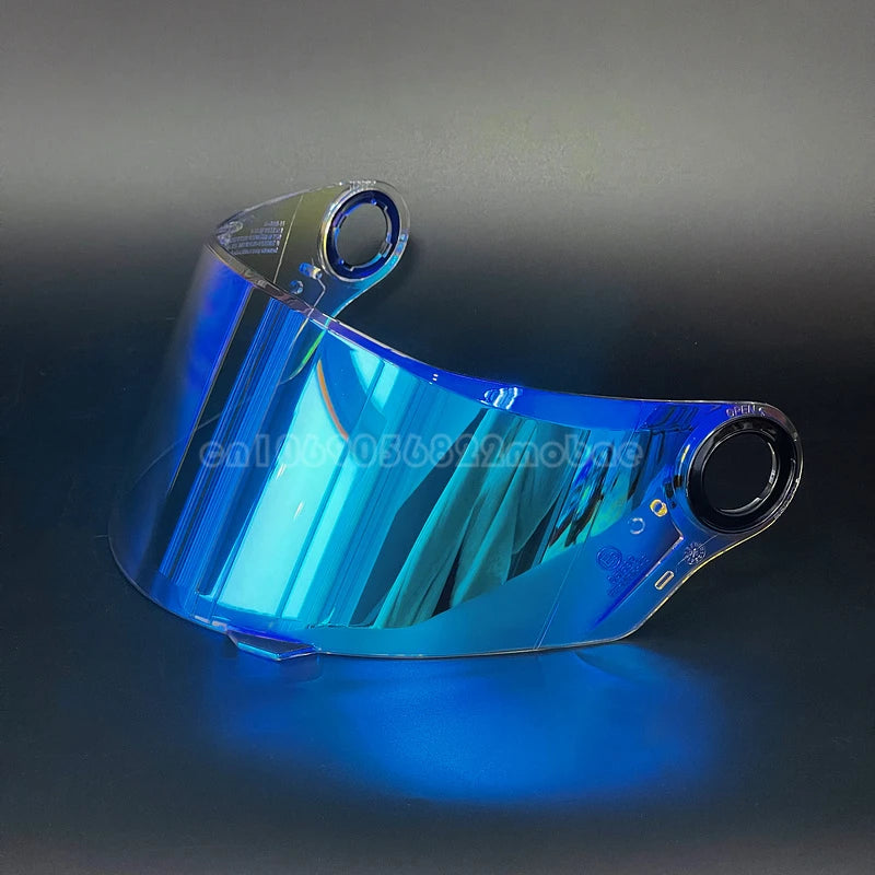 Visor de casco de motocicleta transparente con tinte azul y forma curva, mostrado sobre una superficie oscura.