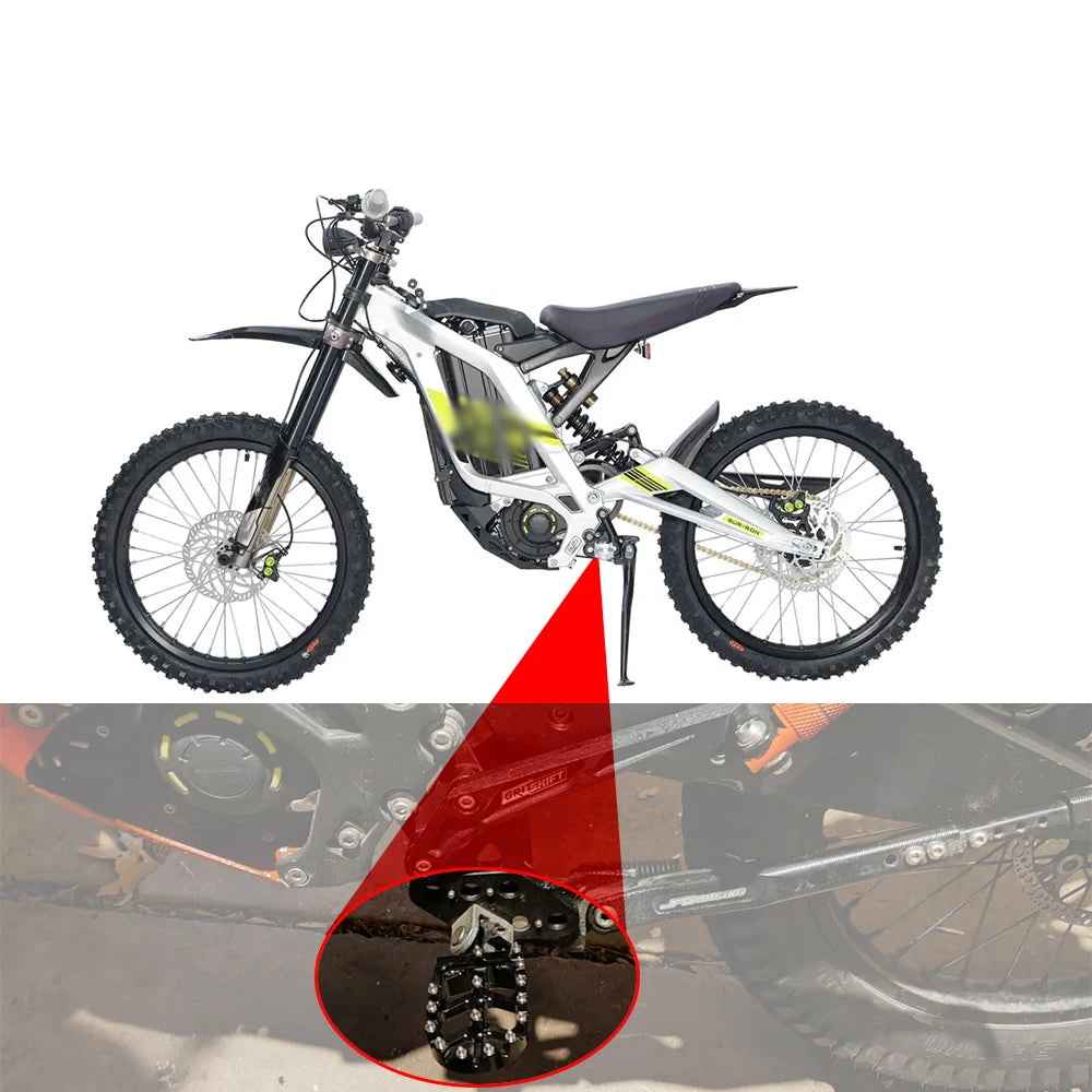 A white dirt bike with heavy-duty CNC foot pegs installed, showing a close-up of the pegs.