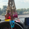 Skull-shaped car air freshener with a purple and blue design hanging from a car vent.