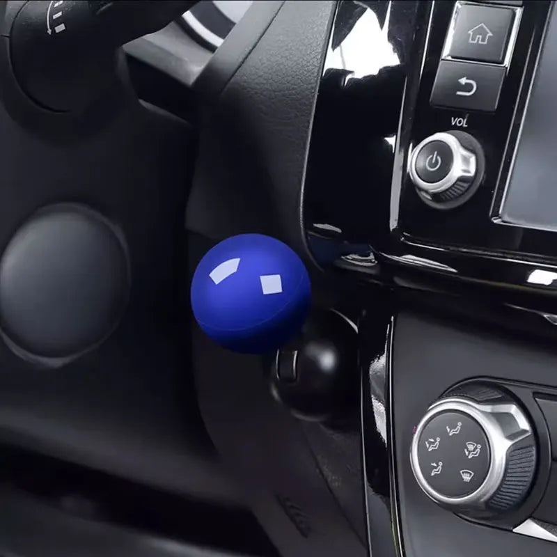 Close-up of a blue push start ignition button cover on a black car interior panel.