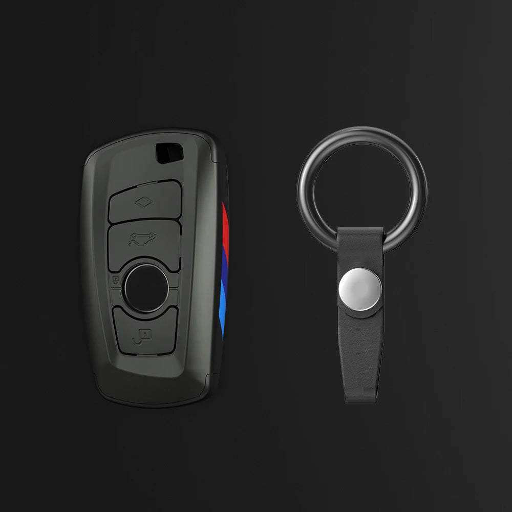 Un juego de fundas para llaves de coche negro, mostrando un llavero y un anillo de llaves separado con una llave plateada.