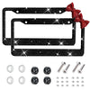 A set of black decorative license plate frames with red bow accents and various mounting hardware.