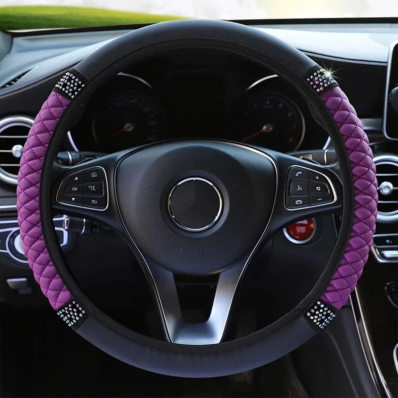 A close-up view of a black steering wheel with a purple embroidered leather cover inside a car interior.