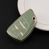 A light green multi-function car key cover rests on a white plate.