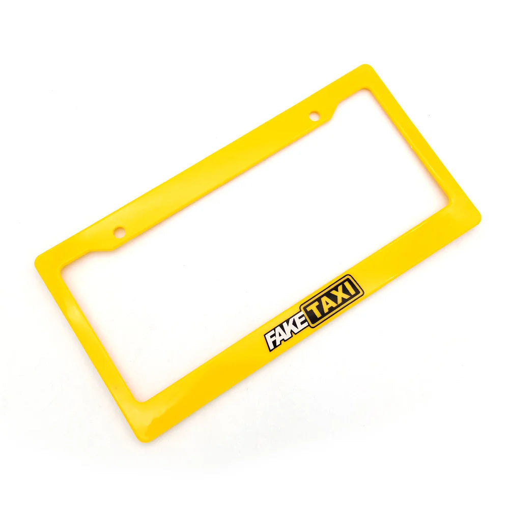 Yellow plastic license plate frame decoration with the text FAKE TAXI