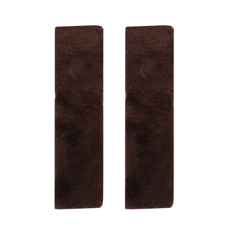 A pair of dark brown luxury car seatbelt shoulder pads.