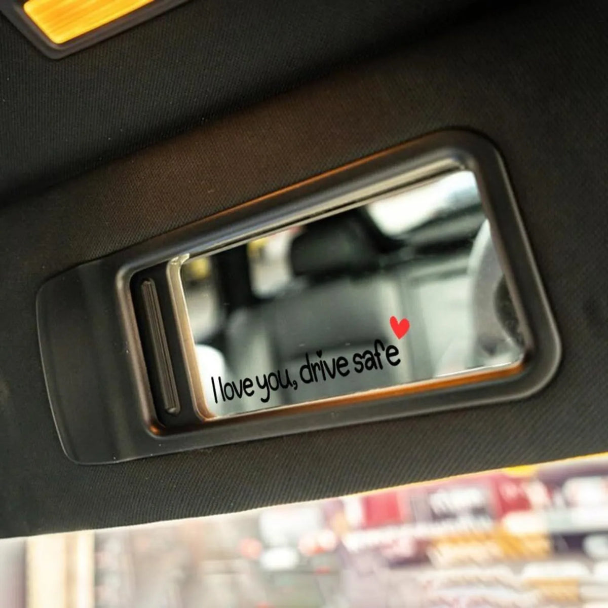 Autocollant vinyle en forme de cœur avec le texte « I love you drive safe » affiché sur un panneau de garniture de voiture.