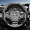 Close-up view of a Lexus steering wheel with carbon fiber trim and leather grips.