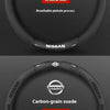 A black carbon fiber steering wheel cover featuring a ventilation hole and carbon-grain suede texture.