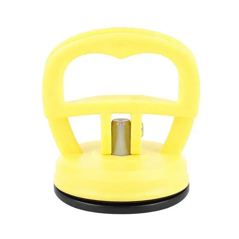 Outil à tire-dents avec ventouse jaune et manche en plastique.