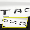 Black and white 3D letter cover emblems for a Toyota Tacoma tailgate.