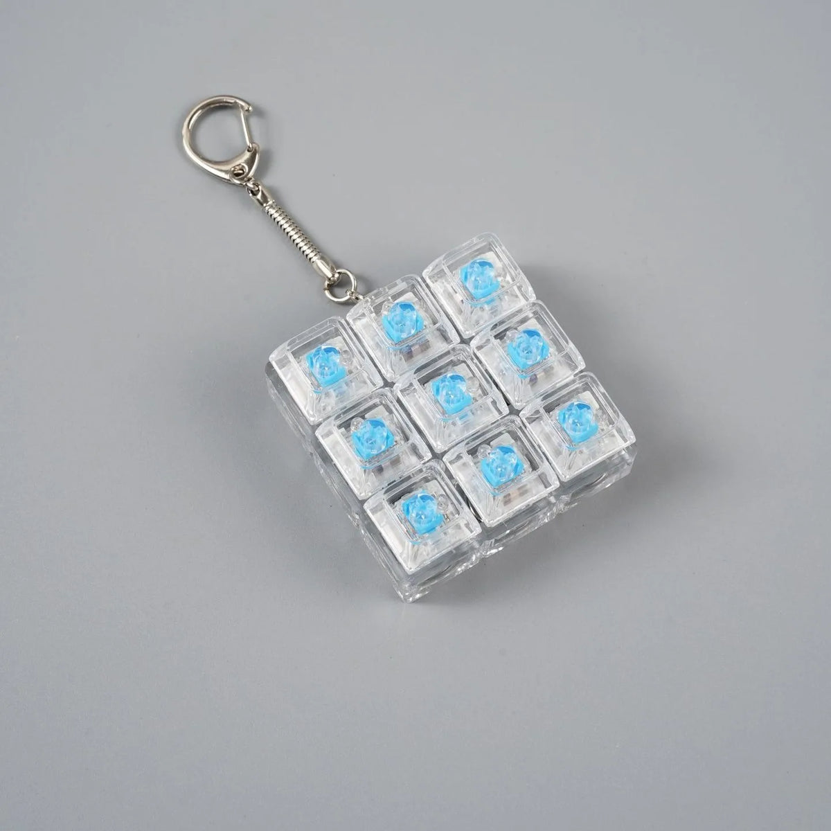 A clear acrylic fidget toy keychain with multiple blue LED lights attached to a silver keyring.