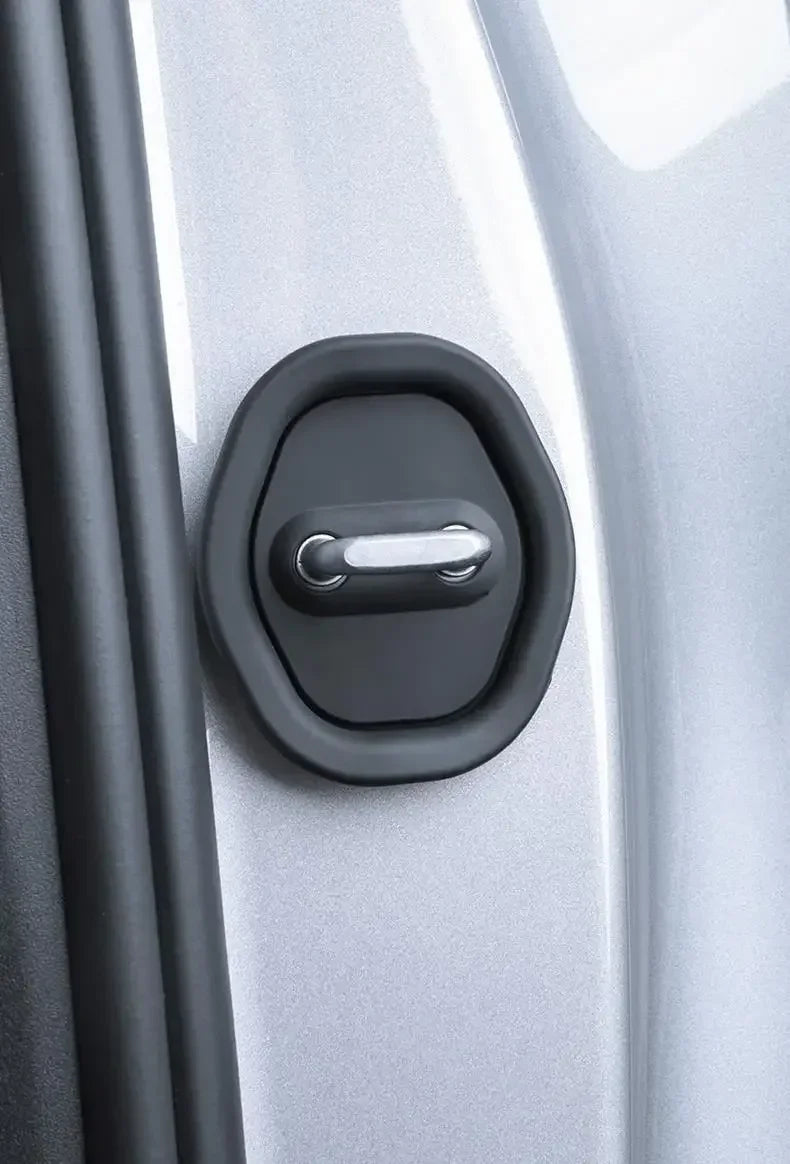 Close-up of a black silicone door damping guard with a silver latch on a light gray car door.