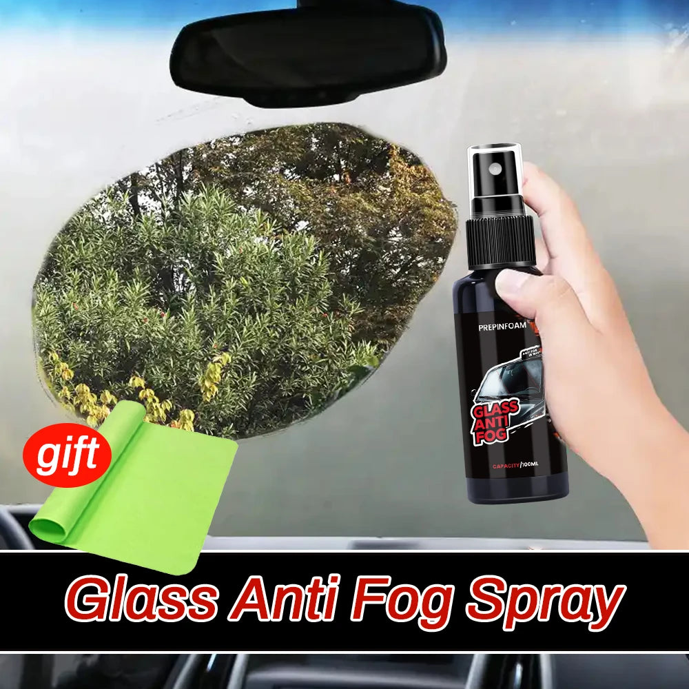 A hand holds a black glass bottle of Anti-Fog Glass Spray with a green applicator, positioned above a dark windshield.