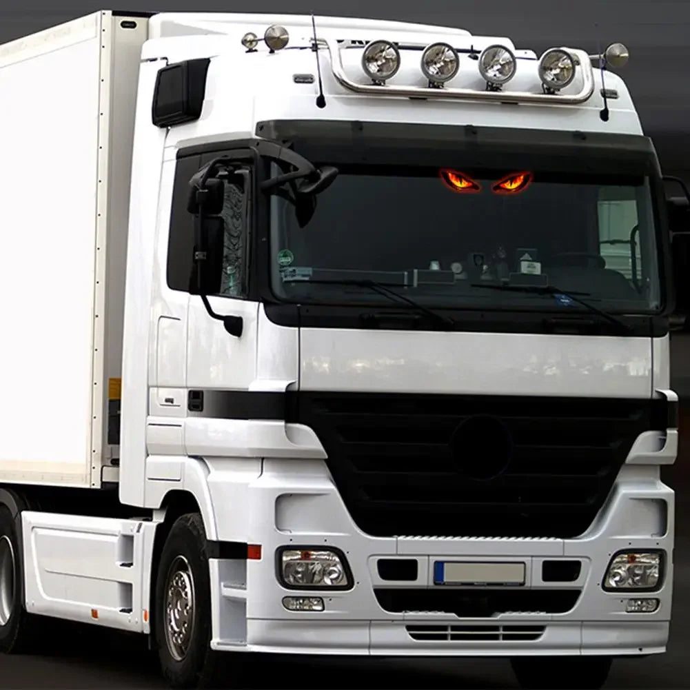 شاحنة بيضاء بسقف حامل وأضواء نيون تظهر من الأمام.