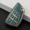 A teal multi-function car key cover with gold accents resting on a dark surface.