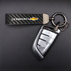 A silver metal key fob attached to a black Chevrolet branded keychain and keyring.