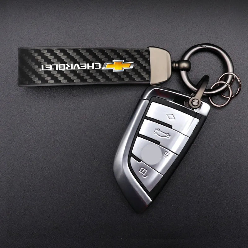 A silver metal key fob attached to a black Chevrolet branded keychain and keyring.