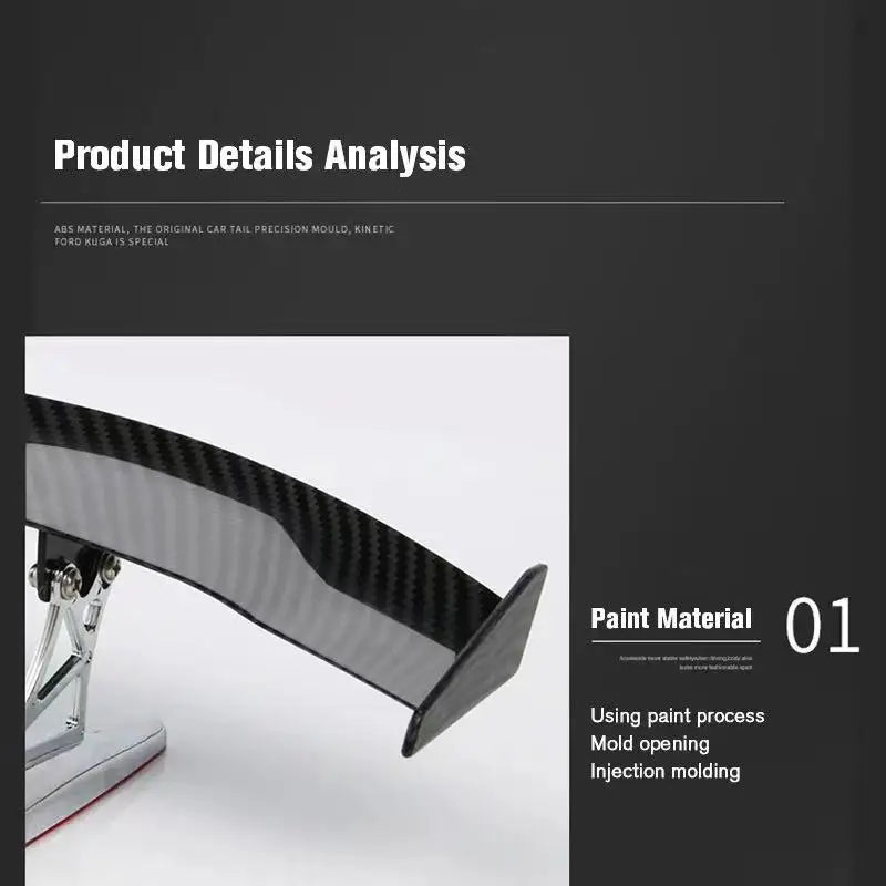 A close-up view of a black carbon fiber rear car spoiler wing component.
