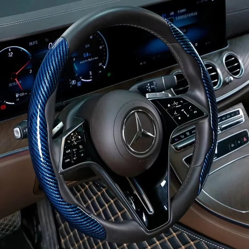 Nahaufnahme eines schwarzen Lenkrads mit blauen Kohlefaser-Akzenten und Mercedes-Benz-Logo.