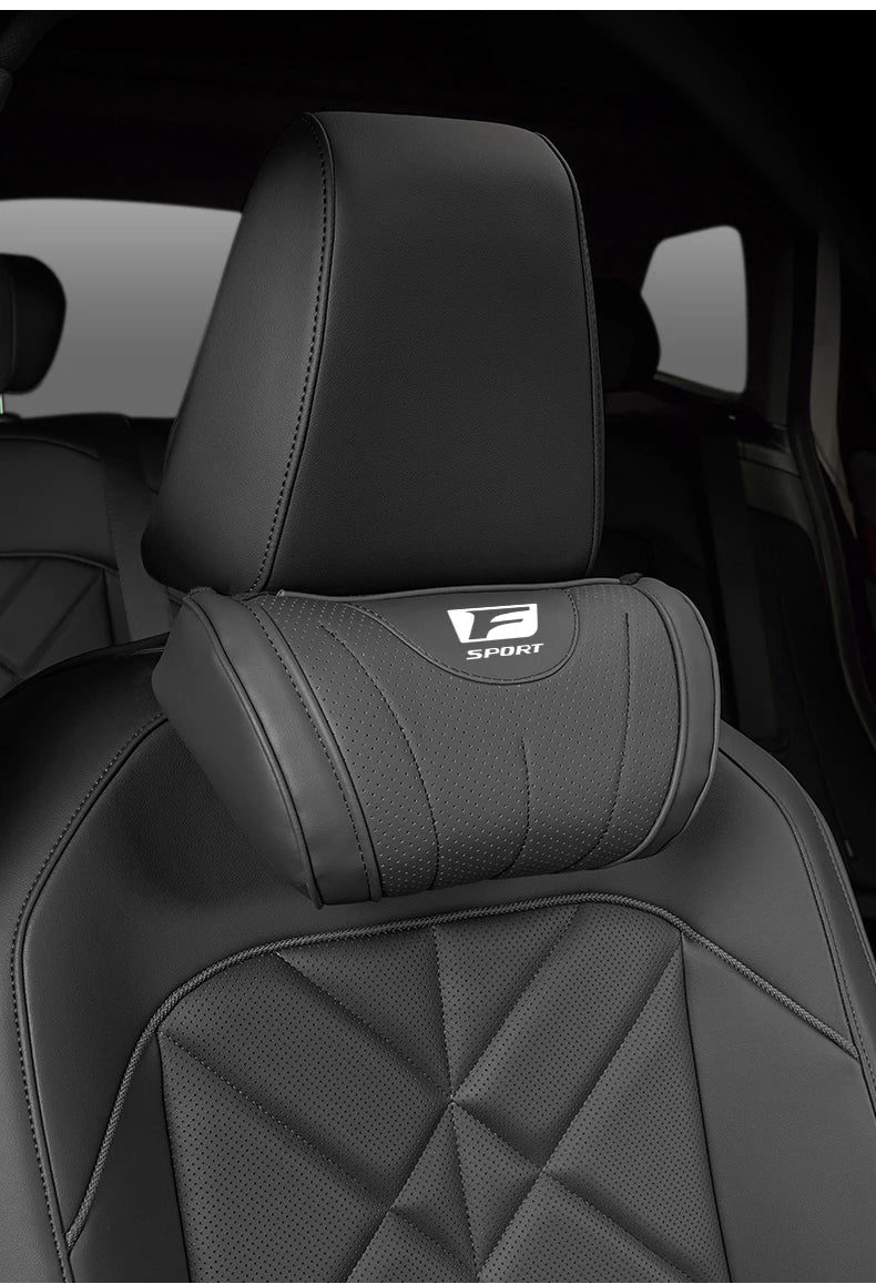 A black ergonomic neck pillow is shown in the interior of a car seat.
