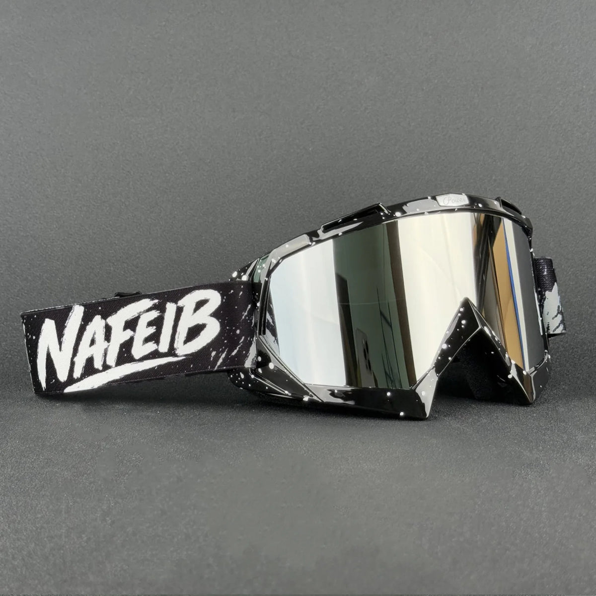 Ein Paar silberner Motorrad- und Offroad-Goggles mit schwarzer Beschriftung am Riemen.